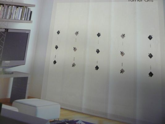 Una sala de estar con cortinas blancas y un televisor de pantalla plana.