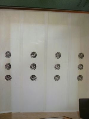 Una sala de estar con una cortina blanca y una silla negra.