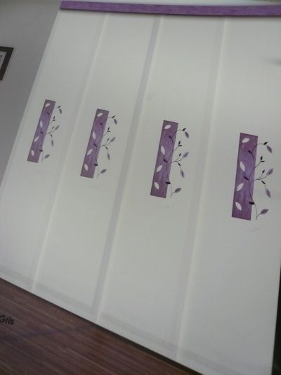 Una pared blanca con flores moradas.