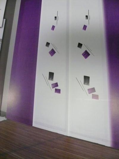 Una habitación con paredes moradas y blancas y suelo de madera.