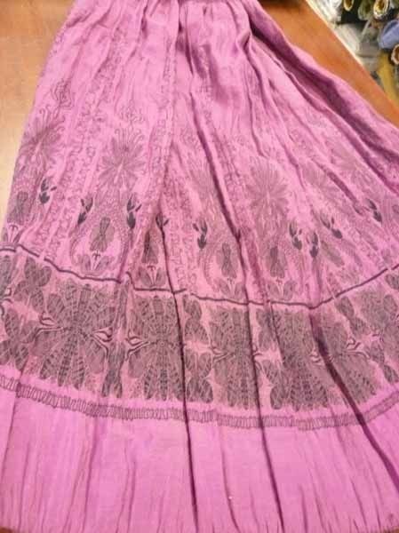 Una falda morada está sentada sobre una mesa de madera.