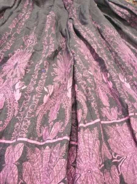 Un primer plano de una tela morada y negra con un estampado floral.