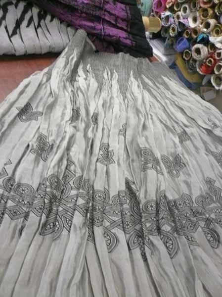 Una falda gris está encima de una mesa de madera.