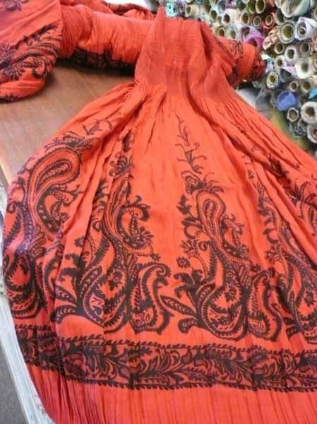 Una tela roja con un patrón de cachemira negro.