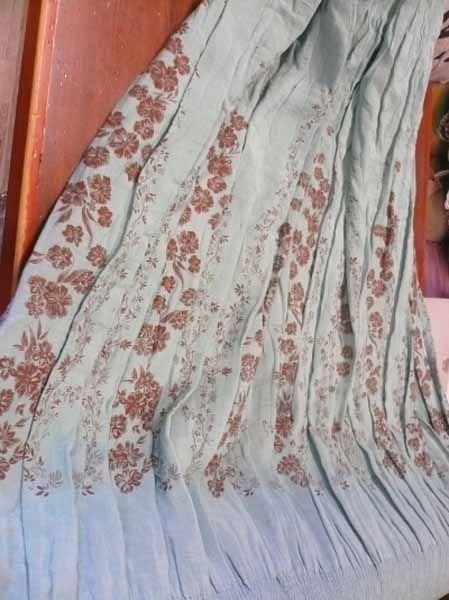 Una manta con flores está sobre una cama.