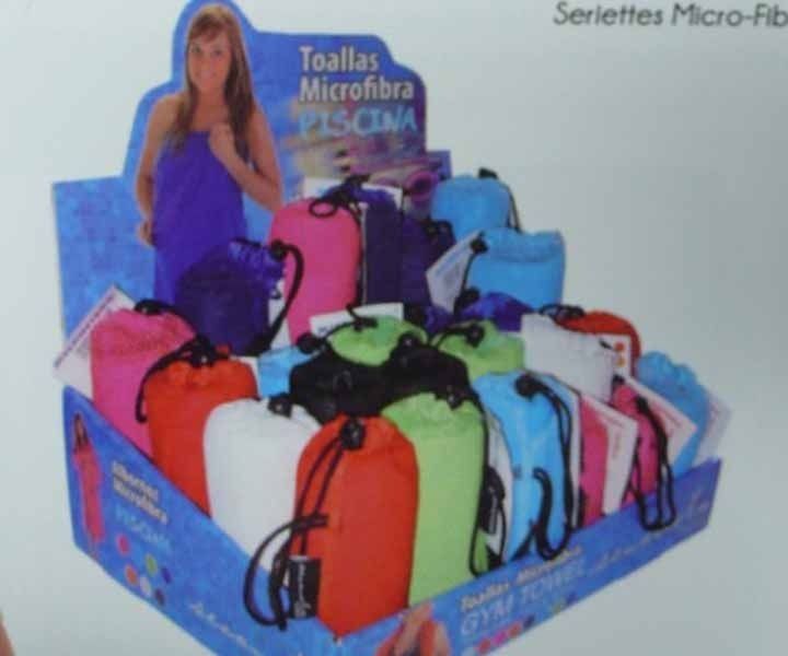 Una exhibición de toallas de piscina de microfibra en varios colores.