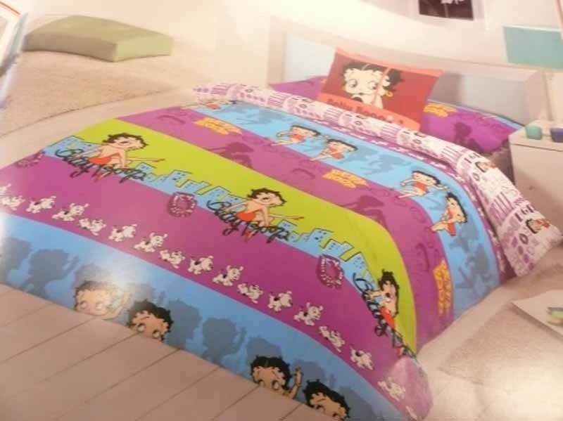 Una cama con un edredón y almohadas de Betty Boop.