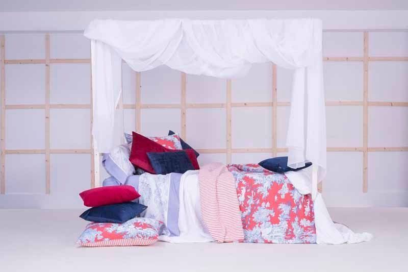 Una cama con dosel y almohadas en una habitación.