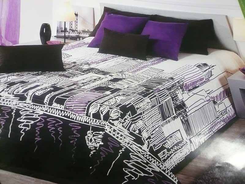Una cama con almohadas moradas y un edredón blanco y negro.