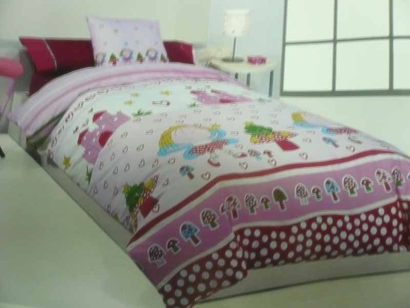 Una cama con un edredón rosa y almohadas encima.