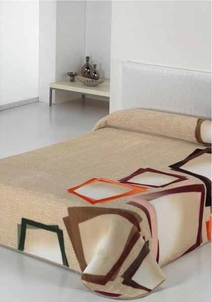 Una cama con una manta que tiene un patrón geométrico.