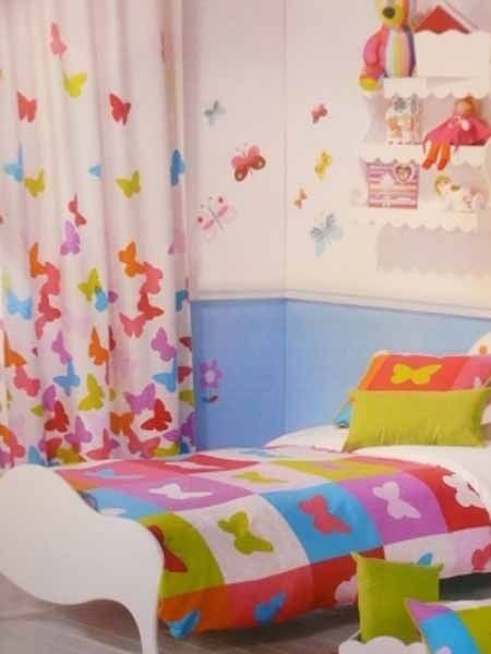 Un dormitorio con una cama y cortinas de colores con mariposas.