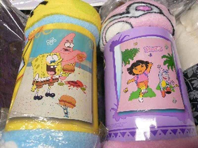 Dos mantas de Bob Esponja y Dora están sentadas una al lado de la otra.