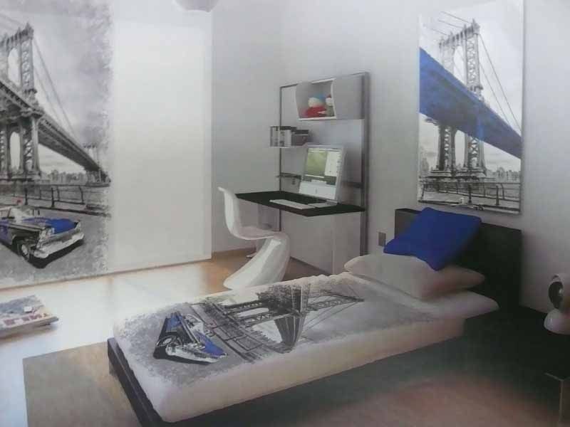 Un dormitorio con una cama y un escritorio con una imagen de un puente en la pared.