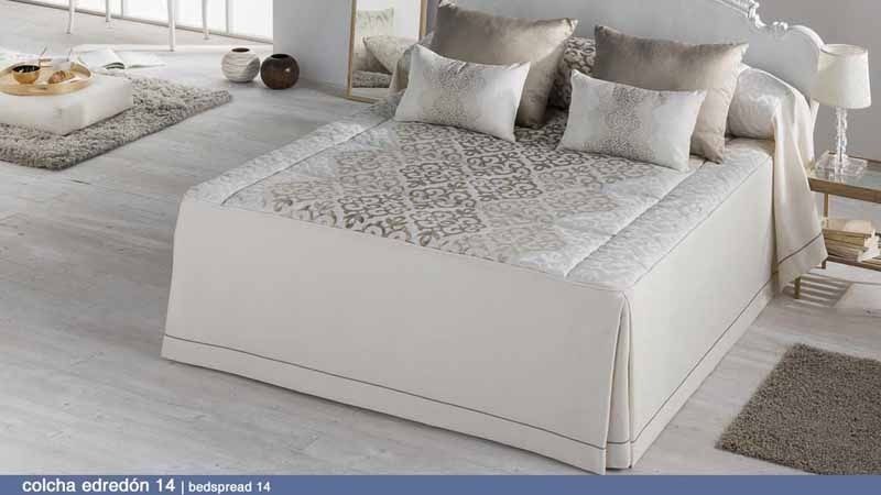 Una cama con un edredón y almohadas encima en un dormitorio.