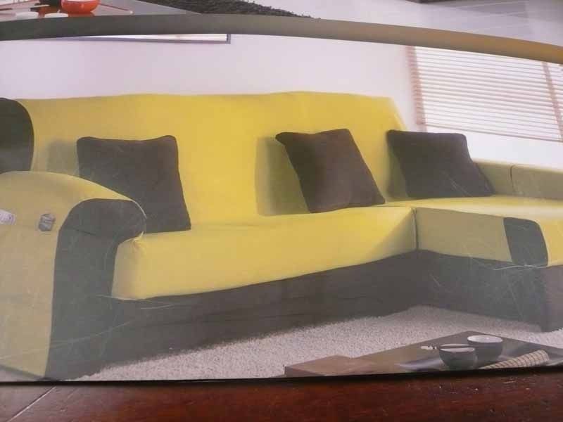 Una sala de estar con un sofá amarillo y almohadas marrones.
