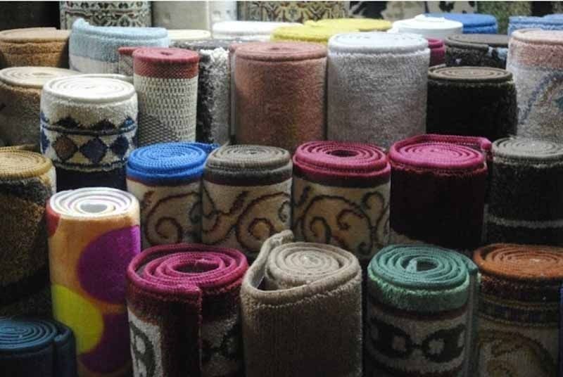 Un montón de rollos de alfombra están apilados uno encima del otro.