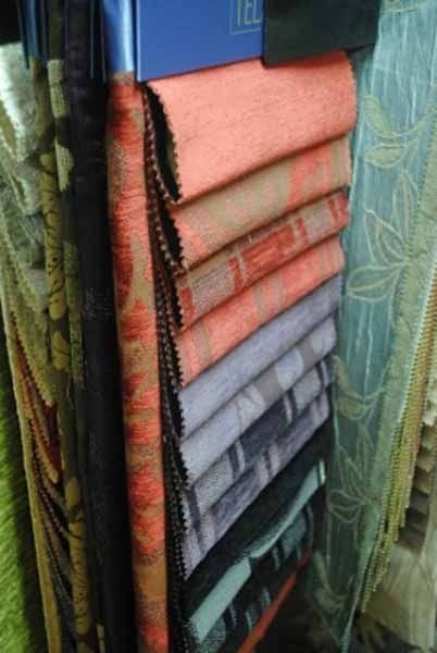 Una variedad de telas se apilan una encima de otra en una tienda.