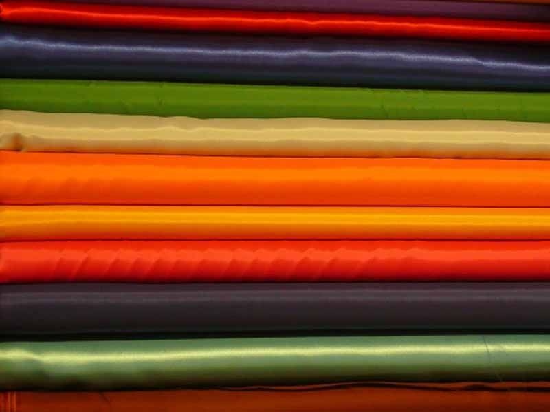 Un montón de telas de diferentes colores se apilan una encima de otra.