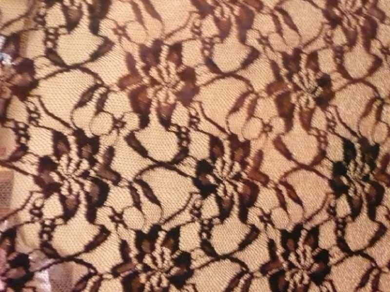 Un primer plano de una tela de encaje marrón con un patrón floral.