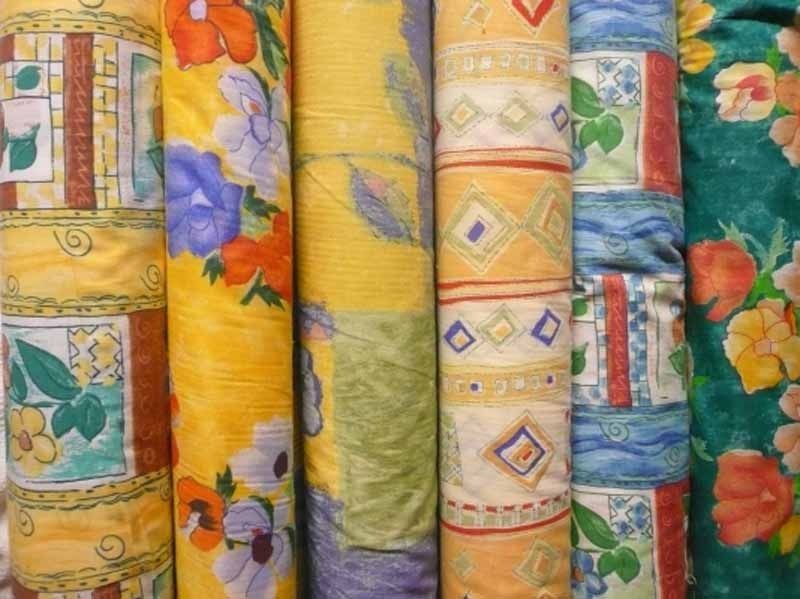 Un montón de rollos de tela con diferentes diseños.