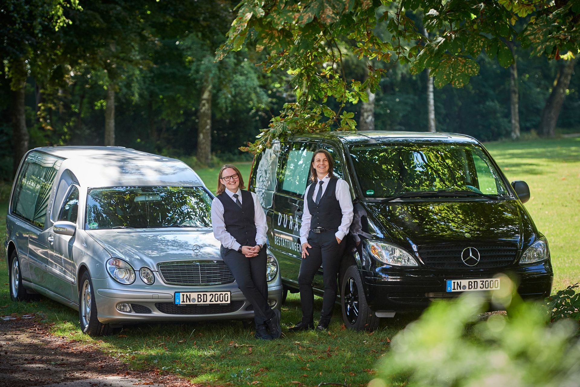 Melanie Dura und Katrin Lüdemann vor den Bestattungswagen