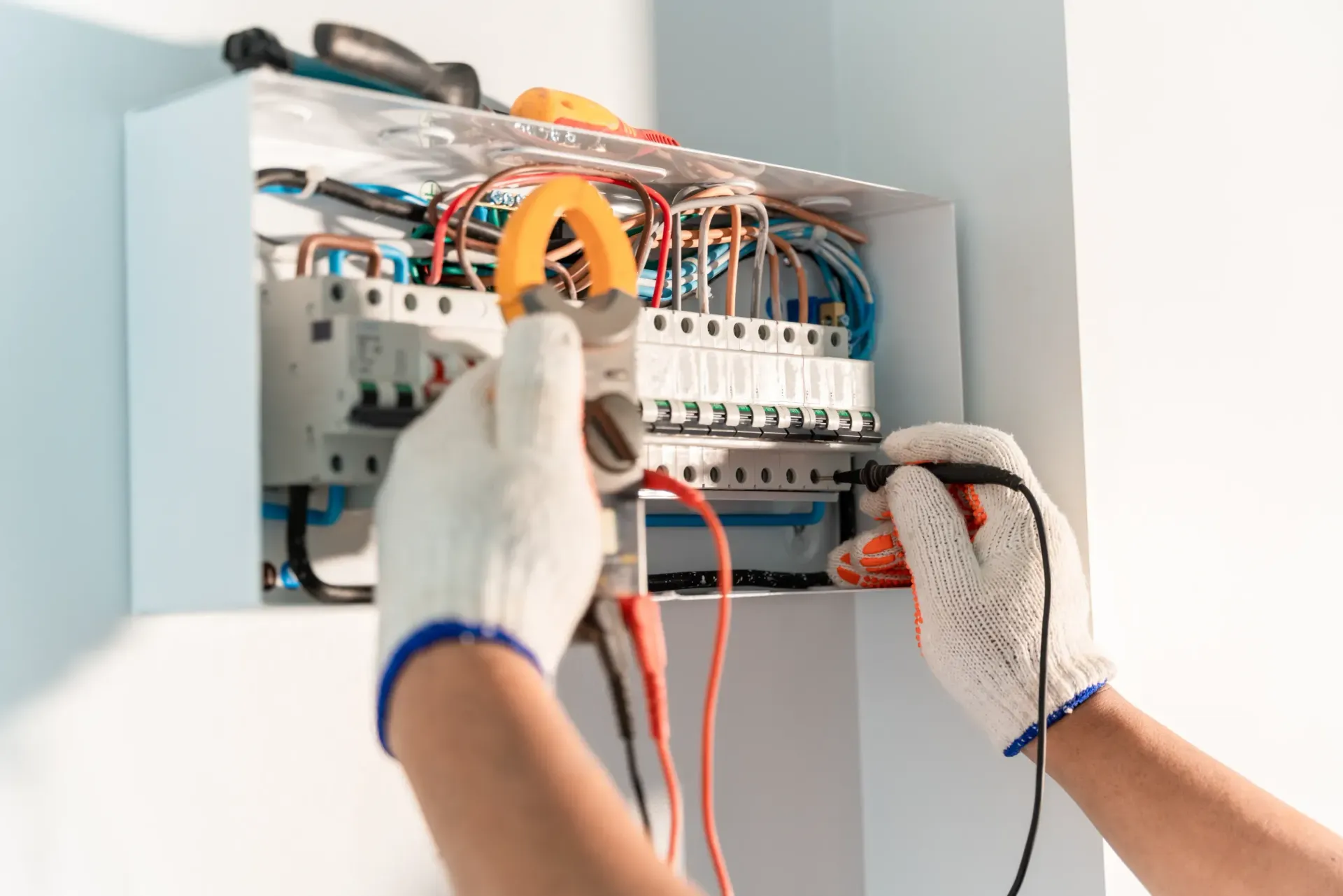 Un electricista está trabajando en una caja eléctrica.