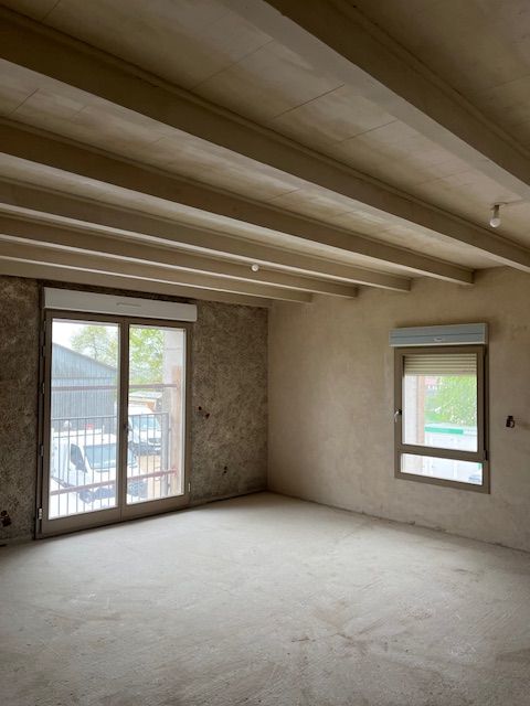 Intérieur d'une maison avec une baie vitrée et une fenêtre.