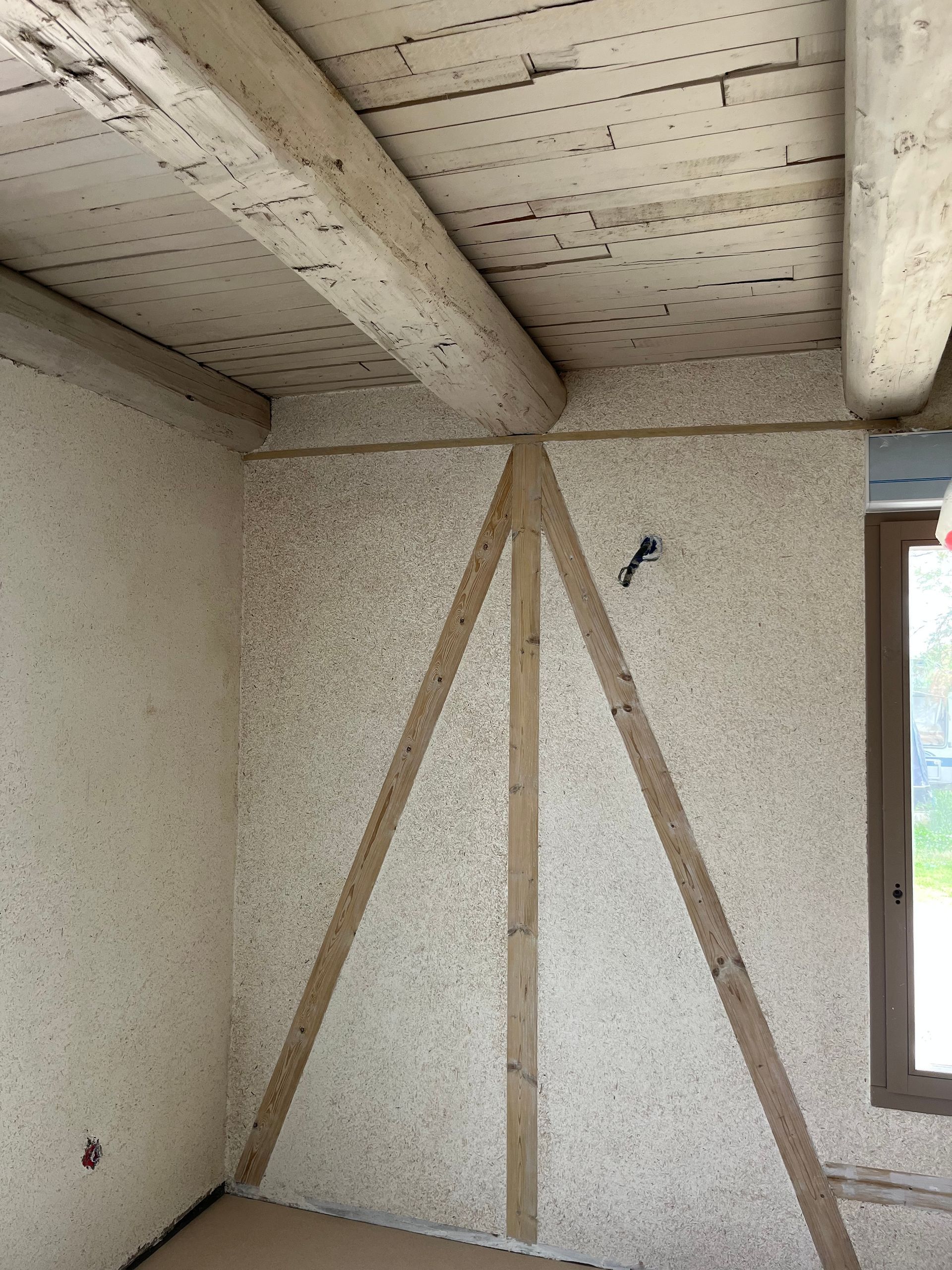 Le mur intérieur et le plafond avec les poutres.