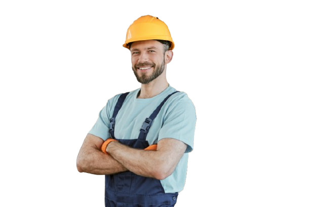 Un ouvrier du bâtiment, les bras croisés, portant un casque jaune et une salopette bleu marine, sourit.