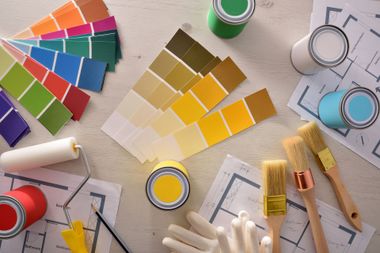 Pots de peinture, échantillons de couleurs, pinceaux et rouleau.