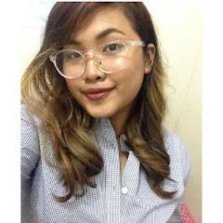 A woman wearing glasses and a striped shirt is taking a selfie.