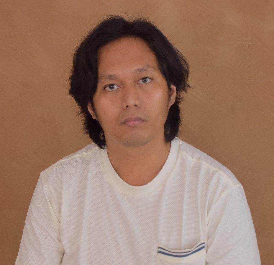 A man wearing a white shirt with a blue stripe on the pocket