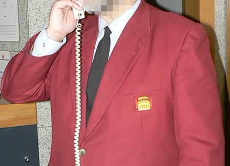 Un hombre con un traje rojo está hablando por teléfono.