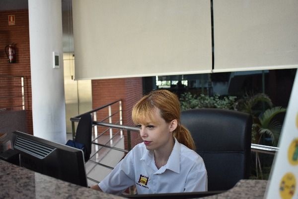 Una mujer está sentada en un escritorio frente a una computadora.