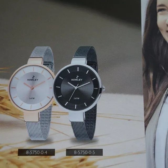 Dos relojes Bentley están expuestos junto a una mujer.