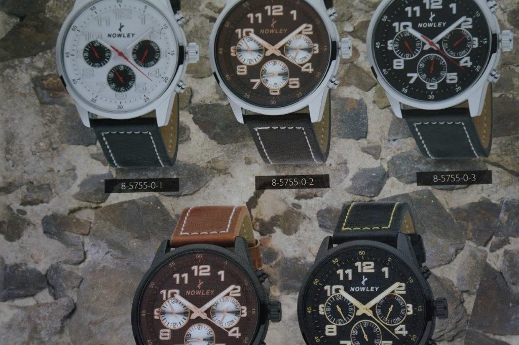 Un grupo de relojes se exhiben en una pared de piedra.