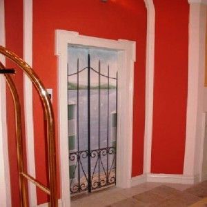 Eine rot-weiße Wand mit dem Gemälde eines Tores darauf. Maler Lüscher GmbH