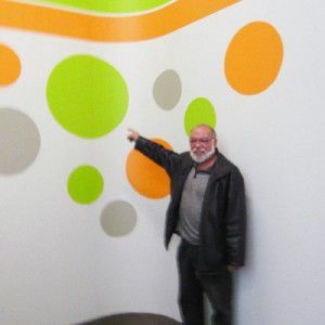 Ein Mann steht vor einer Wand, auf der Kreise aufgemalt sind. Maler Lüscher GmbH