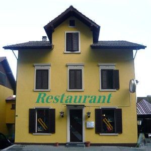 Ein gelbes Gebäude mit dem Wort Restaurant darauf, Maler Lüscher GmbH