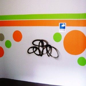 Eine Wand mit Kreisen darauf und Graffiti darauf, Maler Lüscher GmbH