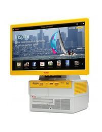 Monitor con marco amarillo sobre una caja multimedia blanca que muestra un velero en el agua con el