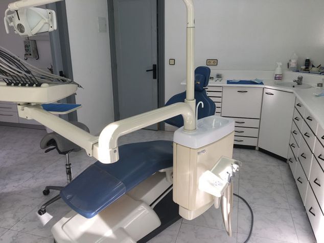 Un sillón dental azul y blanco en un consultorio dental.