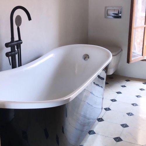 Una bañera en un baño al lado de un inodoro