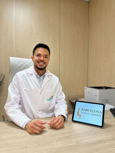 Un médico está sentado en un escritorio con una tableta delante de él.