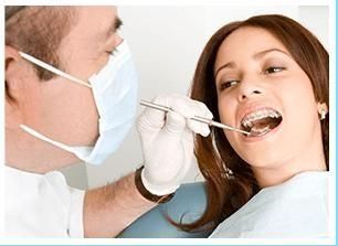 Una mujer está siendo examinada por un dentista.