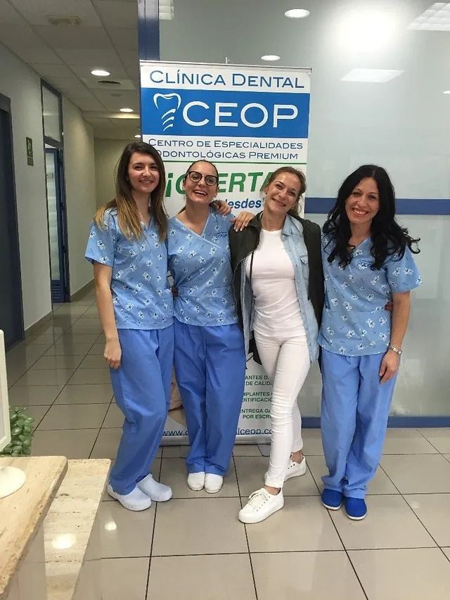 Un grupo de mujeres posa para una fotografía frente a un consultorio dental.