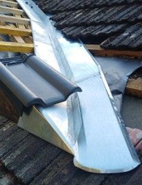 Ein Dach mit einer Dachrinne und einem Ziegel darauf.