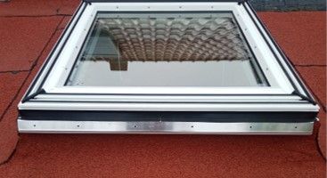 Auf einem roten Dach befindet sich ein Oberlicht.