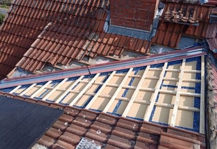 Ein Dach mit vielen Ziegeln und einem Schornstein darauf.